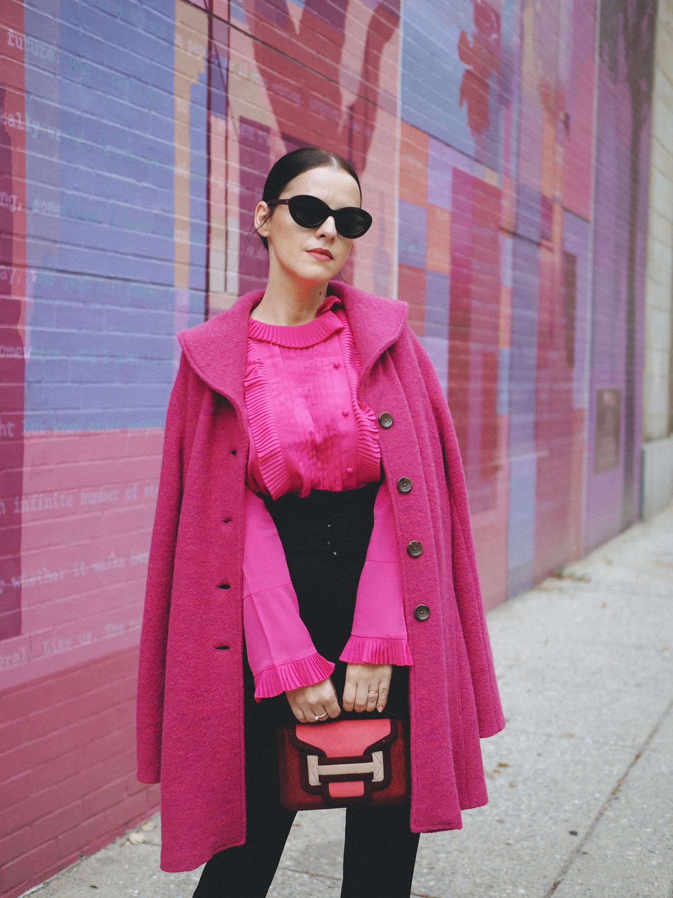 Another popping mix of color is in full display today. This time Fuchsia is the main color and I have not one, but 3 pieces (if I count the hints from the bag, I have 4) in this color. The coat is a vintage piece, old in my closet. I am happy to wear it again in a mix with this black pair of belted high trousers and this ruffled shirt. It's quite a "loud" color combination so there's no need for more accessories if you ask me!